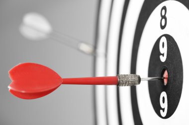 Gri arka plan üzerinde kırmızı Dart ile dart tahtası