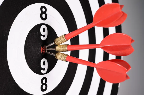 Three red darts in the target center — Stock Photo, Image