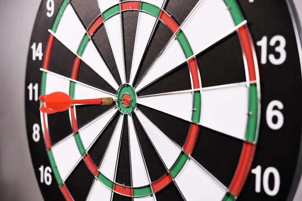 Dartboard with red darts on gray background — Stock Photo, Image