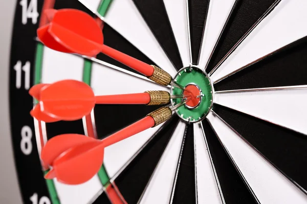 Three red darts in the target center — Stock Photo, Image