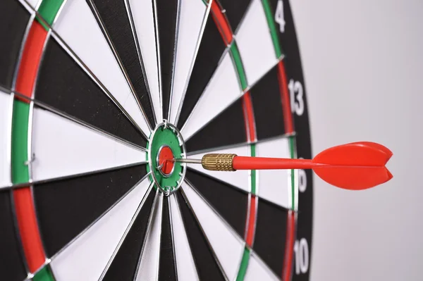 Dartboard with red darts on gray background — Stock Photo, Image