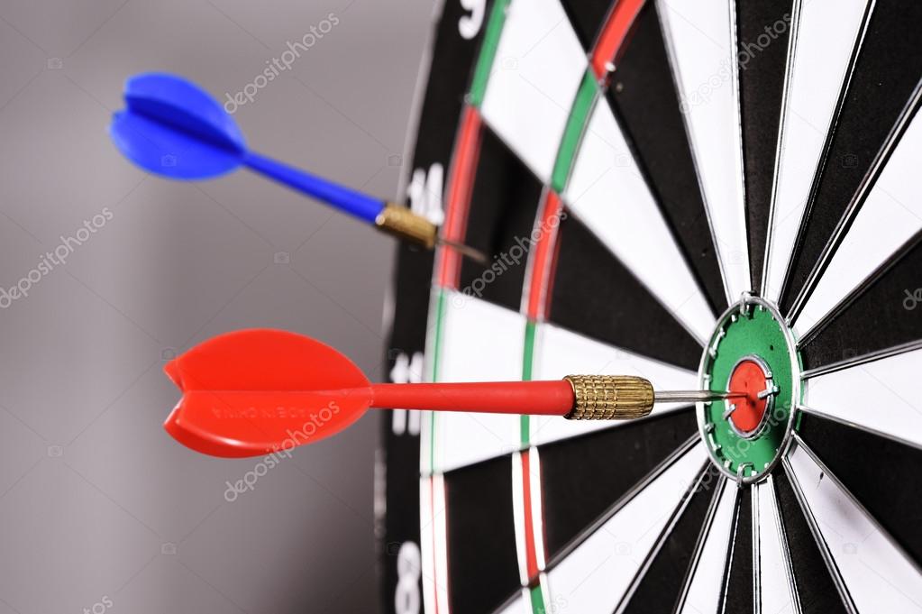 Dartboard with darts on gray background