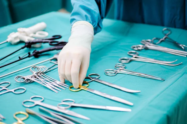 Instruments chirurgicaux stérilisés avec une main saisissant un outil — Photo