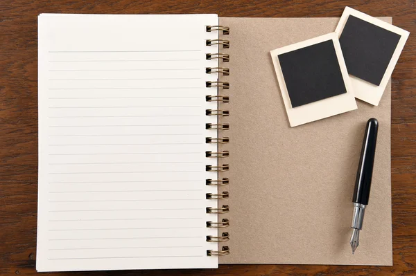 Lege notebook met pen en foto frames — Stockfoto