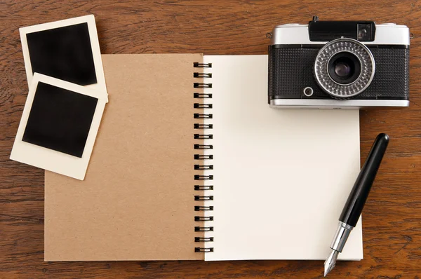 Leeres Notizbuch mit Stift, Fotorahmen und Kamera — Stockfoto