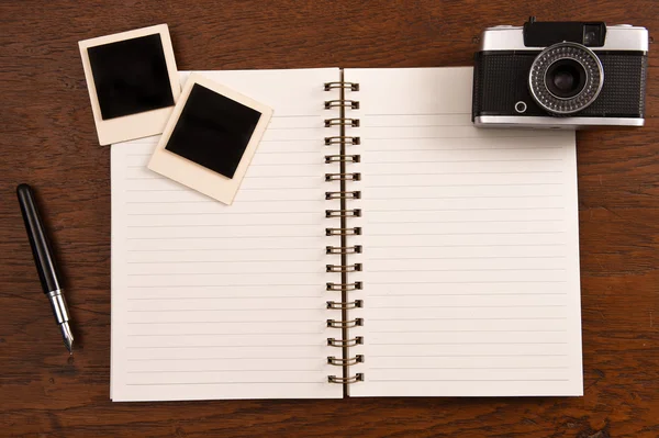 Caderno em branco com caneta, molduras para fotos e câmera — Fotografia de Stock