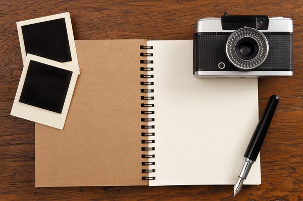 Leeres Notizbuch mit Stift, Fotorahmen und Kamera — Stockfoto