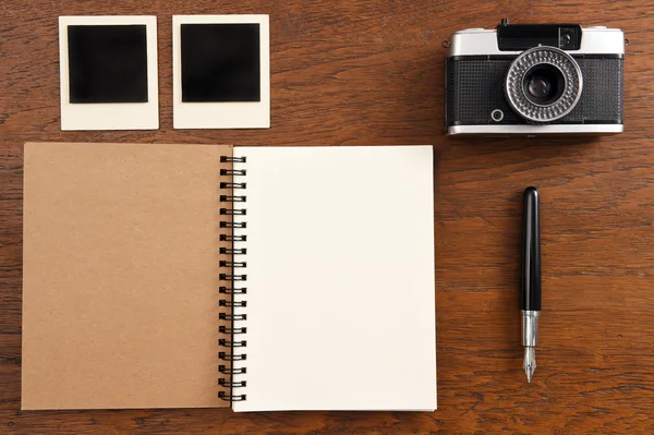 Leeres Notizbuch mit Stift, Fotorahmen und Kamera — Stockfoto