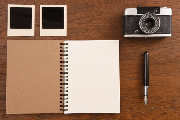 Tom anteckningsbok med penna, fotoramar och kamera — Stockfoto