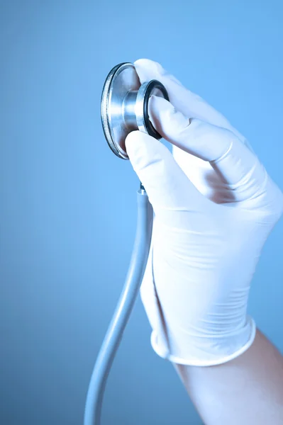 Hand met een stethoscoop nemen met blauw filter — Stockfoto