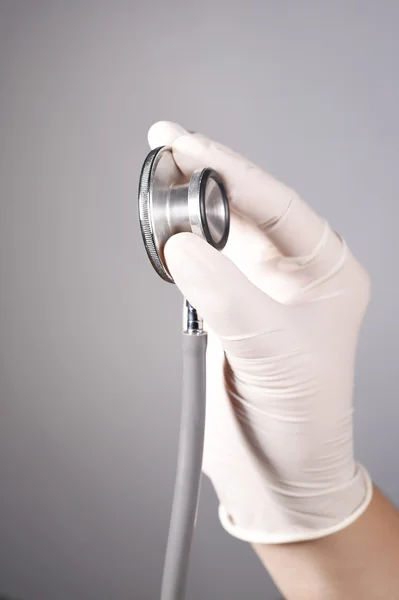 Hand hält ein Stethoskop — Stockfoto