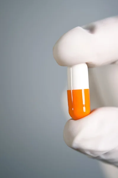 Capsule pill in hand on gray background — Stock Photo, Image