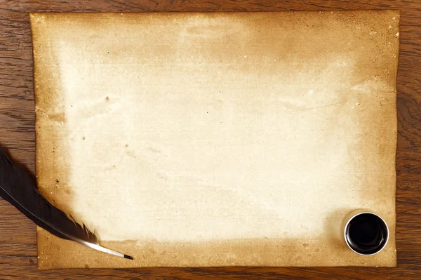 Старая бумага на коричневой текстуре дерева с перьями и чернилами — стоковое фото