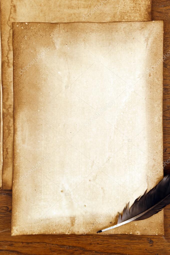 Old paper with feather on brown wood texture