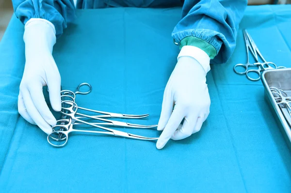 Detail shot of steralized surgery instruments with a hand grabbing a tool — Stock Photo, Image