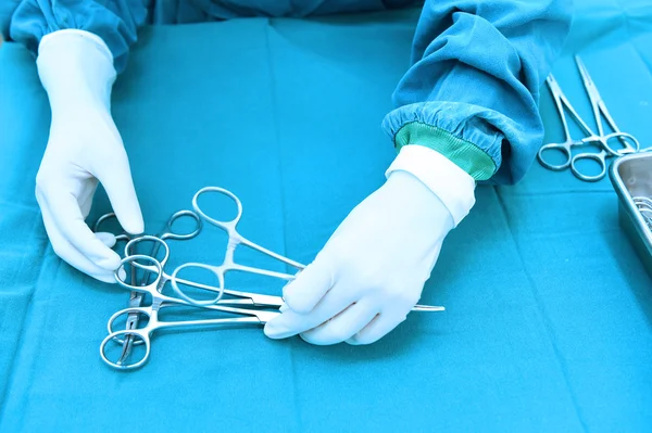 Detail shot of steralized surgery instruments with a hand grabbing a tool — Stock Photo, Image