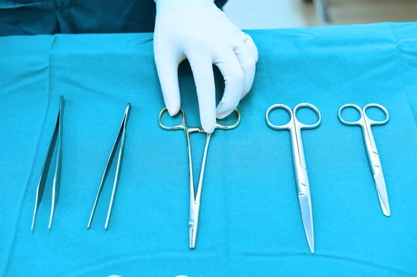 Detail shot of steralized surgery instruments with a hand grabbing a tool — Stock Photo, Image