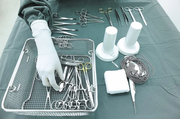 Detail shot of steralized surgery instruments with a hand grabbing a tool — Stock Photo, Image