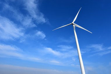 Bulutlu mavi gökyüzü arkaplanına karşı rüzgar türbini