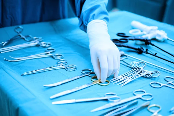 Detail shot of steralized surgery instruments with a hand grabbing a tool — Stock Photo, Image