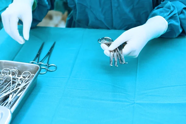 Detail shot of steralized surgery instruments with a hand grabbing a tool — Stock Photo, Image