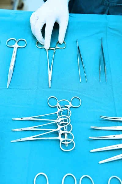 Detalhe tiro de instrumentos de cirurgia esterilizados com uma mão agarrando uma ferramenta — Fotografia de Stock