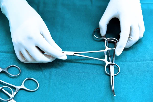 Detail shot of steralized surgery instruments with a hand grabbing a tool — Stock Photo, Image