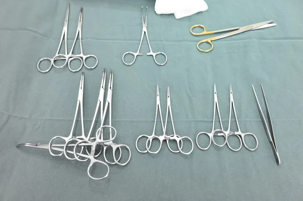 Detalhe tiro de instrumentos de cirurgia esterilizados com uma mão agarrando uma ferramenta — Fotografia de Stock