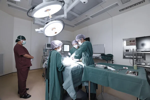 Groep van dierenarts chirurgie in operatie kamer nemen met selectieve kleur techniek en kunst verlichting — Stockfoto