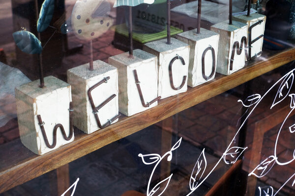 Приветственный знак на деревянном столе
