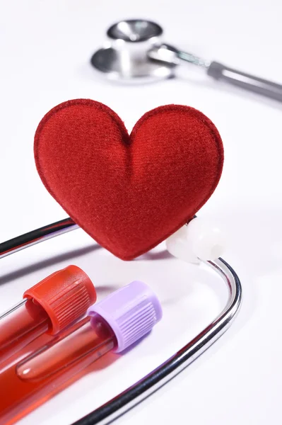 Steteskop ve kan testi tüp üzerinde kırmızı kalp — Stok fotoğraf