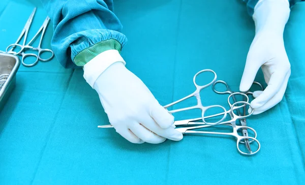 Detail shot of steralized surgery instruments with a hand grabbing a tool — Stock Photo, Image