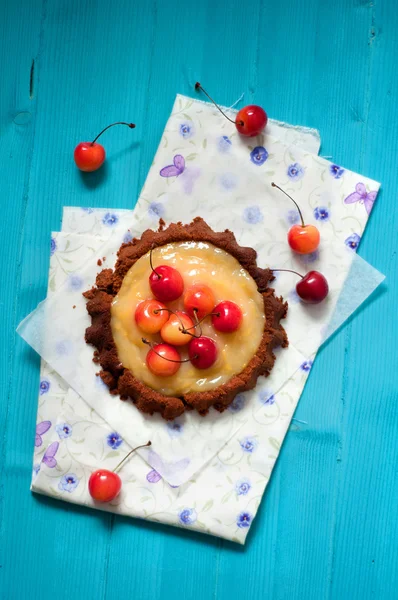 Tartlets mavi bir arka plan üzerinde kiraz ile limon kremalı