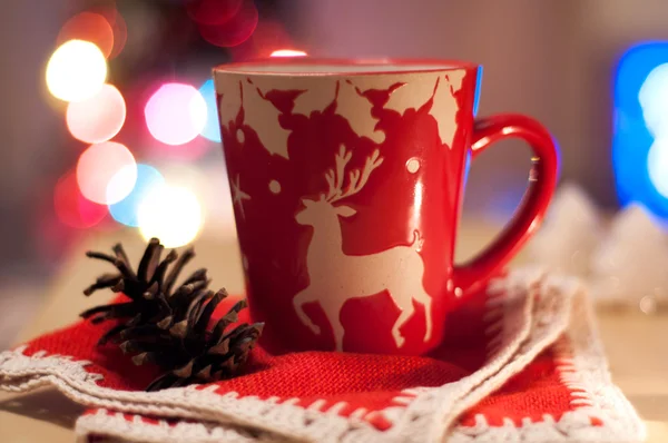 Red Cup on a red cloth on a background of colored lights — Stock Photo, Image