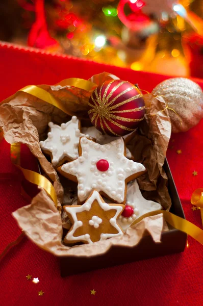 Noel ağacının arka planında hediye kutusundaki kurabiyeler