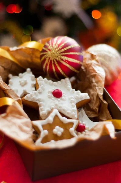 Noel ağacının arka planında hediye kutusundaki kurabiyeler