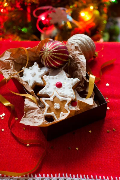 Печенье в подарочной коробке на фоне елки — стоковое фото