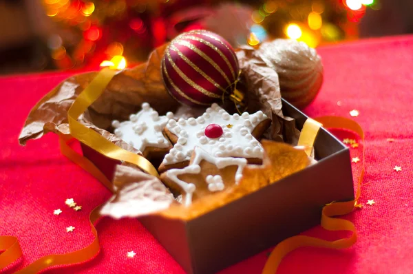 Noel ağacının arka planında hediye kutusundaki kurabiyeler