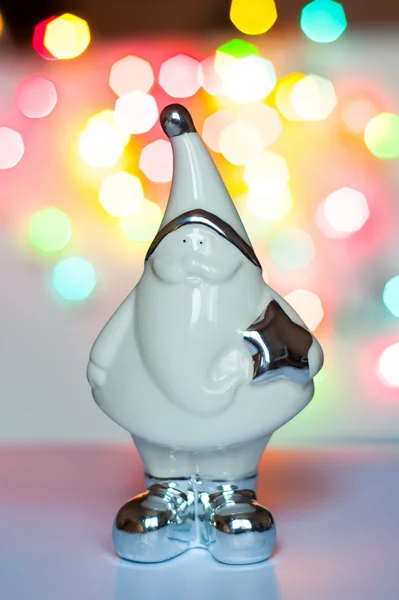 Figurine of Santa Claus in the background of multi-colored lights Stock Image