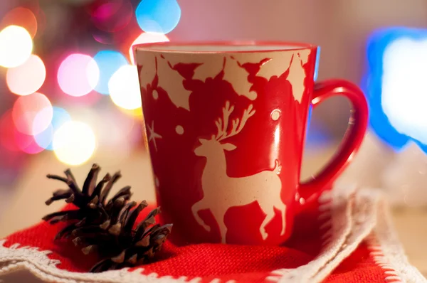 Red Cup on a red cloth on a background of colored lights — Stock Photo, Image