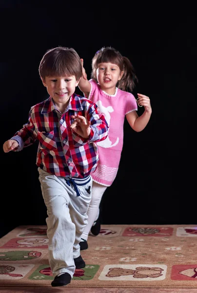 Gyermekek játszanak a fekete háttér — Stock Fotó