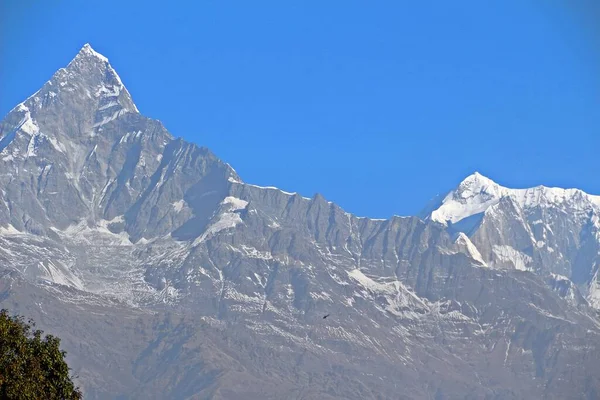 ネパールのSarangkotビューから巨大なMachapuchareの下で非常に小さなヘリコプター — ストック写真