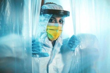 Tam güvenlikli antivirüs donanımlı bir kadın plastik perdenin arkasında saklanıyor.