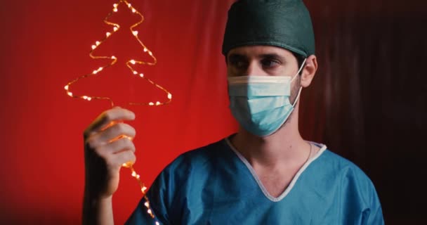 Doctor Holding Christmas Tree Shaped Garland Hand — Stock Video