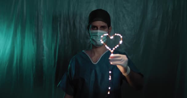 Doctor Sosteniendo Guirnalda Forma Corazón Mano — Vídeo de stock