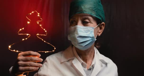 Mujer Doctor Sosteniendo Guirnalda Forma Árbol Navidad Mano — Vídeo de stock