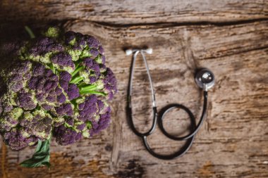 Tahta masada taze karnabahar ve steteskop.