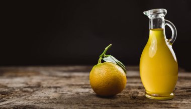 Kavanozda taze sıkılmış limon suyu ve ahşap arka planda limon. 