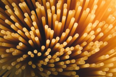 Sarı uzun spagettiyi yakın çekim. Sarı İtalyan makarnası. Çiğ spagetti. Gıda arka plan kavramı.