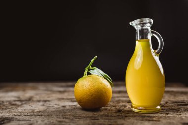 Kavanozda taze sıkılmış limon suyu ve ahşap arka planda limon. 